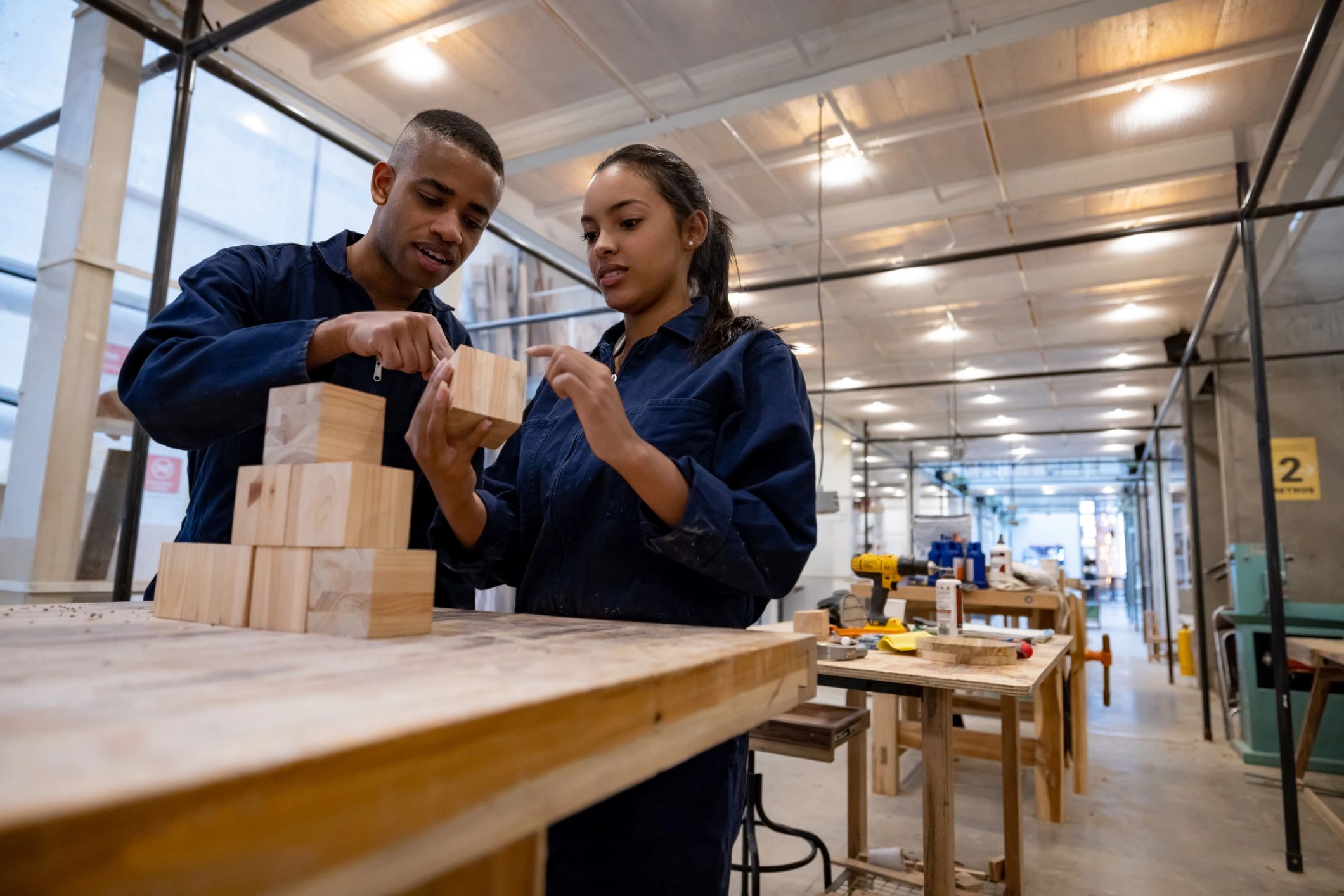 Team member assembling eco-friendly 3D wood puzzle in a sunlit workshop